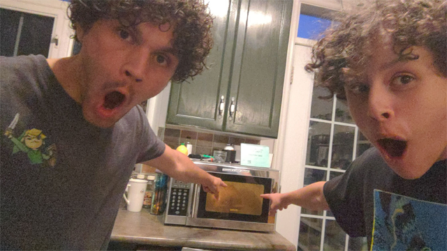 two men enthusiatically point at a microwave